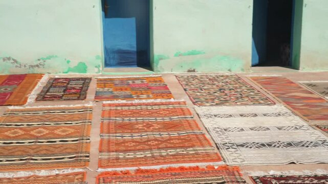Moroccan handcrafted rugs spread out in a typical factory yard