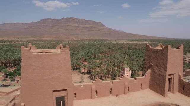 morrocan kasbah in palm valley of draa in desert oasis