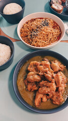 Yangnyeom chikin or korean fried chicken and ramyun noodles with rice served on a casual dining table