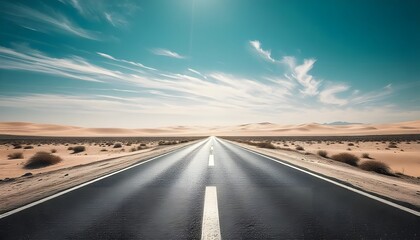 Fototapeta premium Desert Highway leading through dunes under a bright blue sky with light clouds