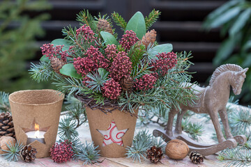 Weihnachts-Arrangement mit Winter-Blumenstrauß mit Skimmia japonica-Blüten Koniferenzweigen und...