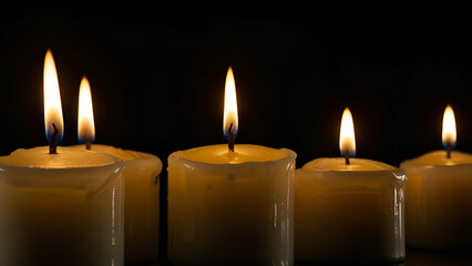 Glowing candles in the dark creating warm cozy light with peaceful ambience and elegant home decor.