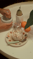 Grinding organic golden flaxseed with a marble mortar and pestle to be added to a cup of overnight oats that shows a springtime healthy breakfast and morning routine 