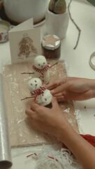 Hand molding DIY air dry clay made of glue and cornstarch into a snowman Christmas decor showing a...