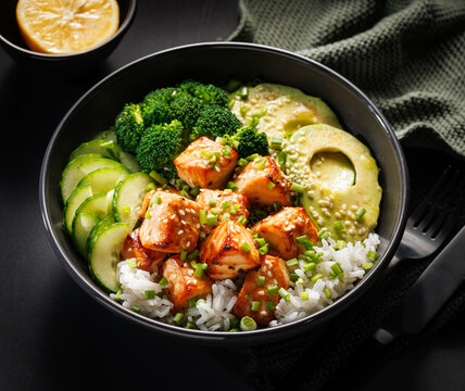Salmon bowl with rice and vegetables, close up view. Healthy and delicious food