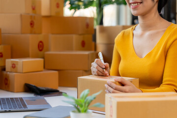 Entrepreneurial Spirit: A confident young woman, radiating joy, prepares a package for delivery, showcasing the energy and dedication of small business owners.