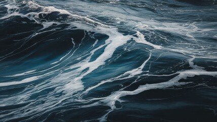 Fototapeta premium An abstract view of ocean waves with rich blue tones and white foam, evoking a sense of calm and serenity.