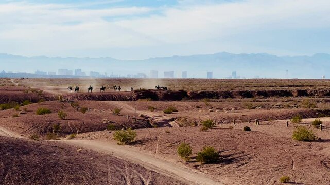 Striking contrast of natural beauty and urban spectacle as horseback riders traverse the desert landscape of Wetlands Park, with the iconic Las Vegas Strip skyline shimmering in the distance.