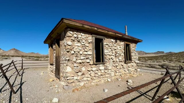 Remarkably intact miner's cabin stands as a time capsule in the haunting Rhyolite ghost town near Death Valley, offering a poignant glimpse into the harsh yet hopeful lives of Gold Rush era prospector