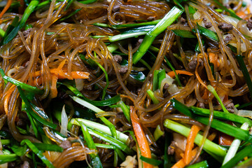 mixing Japchae ingredients in the bowl