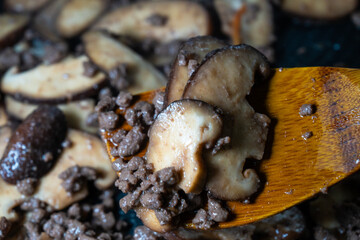 stir-frying the seasoned beef and shiitake mushroom