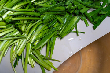moving knife-cut chives from the cutting board to the bowl