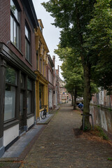 Fototapeta premium Houses with a street, a water canal and boat in the old town of Alkmaar in the Netherlands