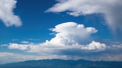 Obraz premium A stunning view of billowy white clouds against a vibrant blue sky, with mountain silhouettes in the background, creating a serene and uplifting atmosphere.