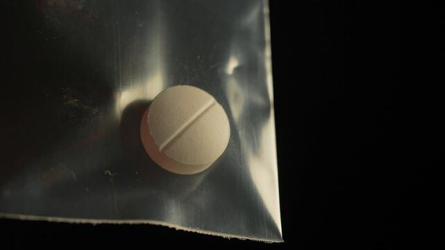 Drugs addicted person just purchased illegal Heroin or Fentanyl like powder substance from the dealer on the street and looking at it. Person ready to have a party. Illegal street drugs epidemic.