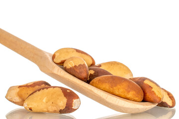 Brazil nuts without shells with wooden  spoon, macro, isolated on white background.