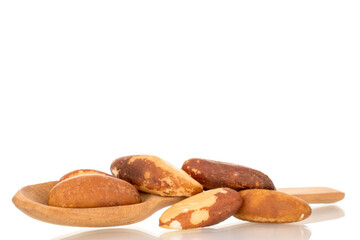 Brazil nuts without shells with  wooden spoon, macro, isolated on white background.