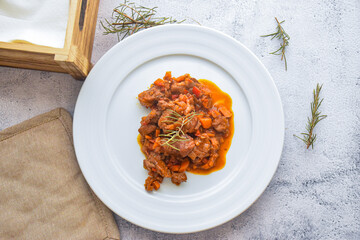 homemade dish of beef stew with tomato sauce. dish at a kitchen table