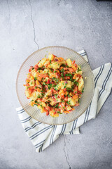 homemade potato salad with peppers on a neutral background