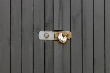 Metal Padlock Securing Wooden Garage Door