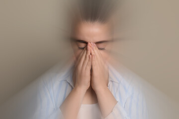 Woman suffering from headache and dizziness on dark beige background