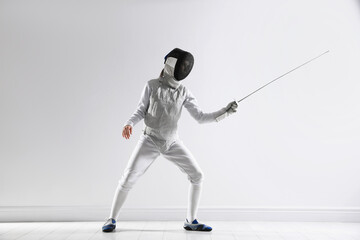 Fencer with epee practicing indoors. Combat sport