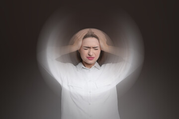 Woman suffering from headache and dizziness on dark brown background