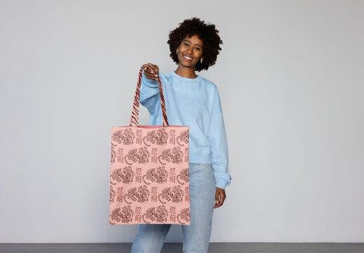 Mockup of Afro black woman smiles holding a blank tote bag
