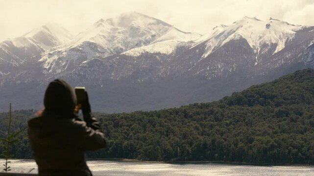 Woman taking pictures of nahuel huapi national lake. tourist viewpoint. 