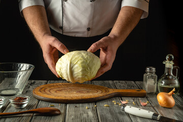 Skilled hands hold a vibrant head of cabbage, ready to be transformed into a savory dish. A rustic...