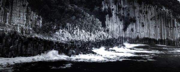 Naklejka premium Black and white seascape photo. Basalt cliffs by the sea.