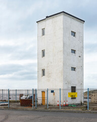 Obraz premium White Harbour Tower Building at Port Entrance with Iron Railing Fence