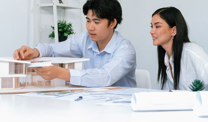 Obraz premium Portrait of cooperative engineer team working together to measure house model by using ruler and architectural equipment. Creative business design and teamwork concept. Immaculate..