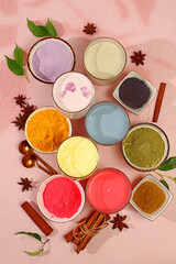 Various matcha tea lattes with milk on light background and matcha powder in cups. Traditional Indian trendy drink rich in antioxidants, used for weight loss and treatment