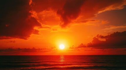 Fototapeta premium Vibrant sunset over the ocean with dramatic clouds and reflections on the water Copy Space