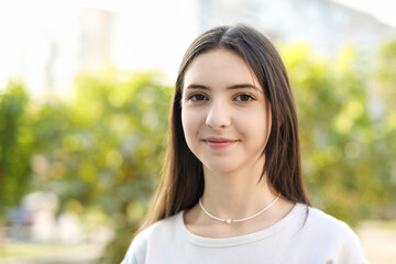 Portrait of beautiful teenage girl on city street. Space for text