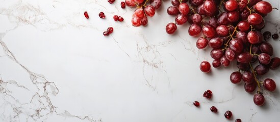 Red grapes on a marble surface with scattered grapes and copy space for text placement