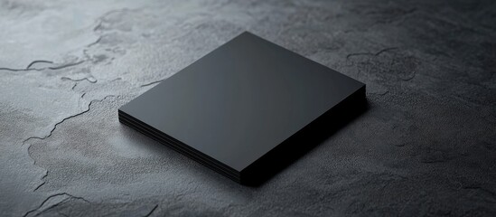 Elegant black reflective business card on textured surface with ample copy space for personalized text and design elements.