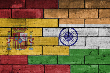 colourful painted big flag of spain and flag of india on a massive old brick wall background. concept