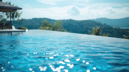 Luxury infinity pool with clear blue water overlooking lush green hills under a bright sky. Copy Space.