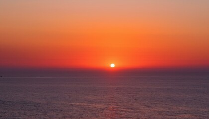 Obraz premium 멀리 수평선 위로 떠오르는 선명한 일출, 붉고 따뜻한 색감의 태양