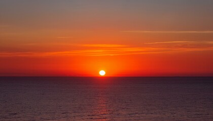 멀리 수평선 위로 떠오르는 선명한 일출, 붉고 따뜻한 색감의 태양