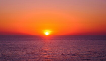 멀리 수평선 위로 떠오르는 선명한 일출, 붉고 따뜻한 색감의 태양