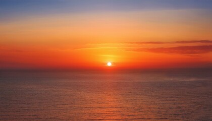 Obraz premium 멀리 수평선 위로 떠오르는 선명한 일출, 붉고 따뜻한 색감의 태양