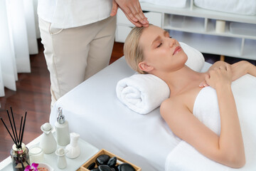 Obraz premium Caucasian woman enjoying relaxing anti-stress head massage and pampering facial beauty skin recreation leisure in dayspa modern light ambient at luxury resort or hotel spa salon. Quiescent