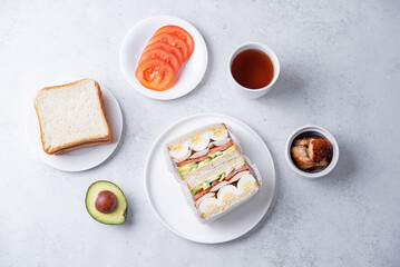 Eggs fired meat avocado tomato sandwiches in a plate