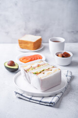 Eggs fired meat avocado tomato sandwiches in a plate