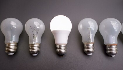 일렬로 나란히 정렬된 여러 개의 하얀 전구 중 하나만 빛을 밝히고 있는 모습