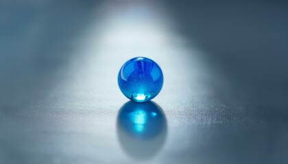무채색의 회색 배경 위에 하나의 푸른 구슬이 반짝이며 중앙에 놓여 있다. 구슬은 투명한 빛을 반사해 강조된다