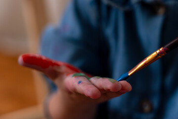 Little girl painting on her hand 